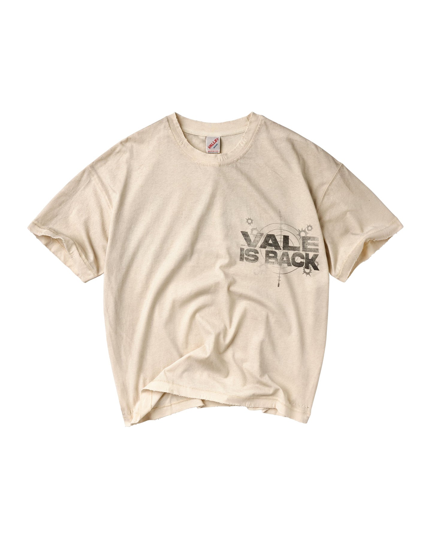 A cream-colored short-sleeve t-shirt with a distressed black graphic on the left chest that reads 'VALE IS BACK' with a compass design.