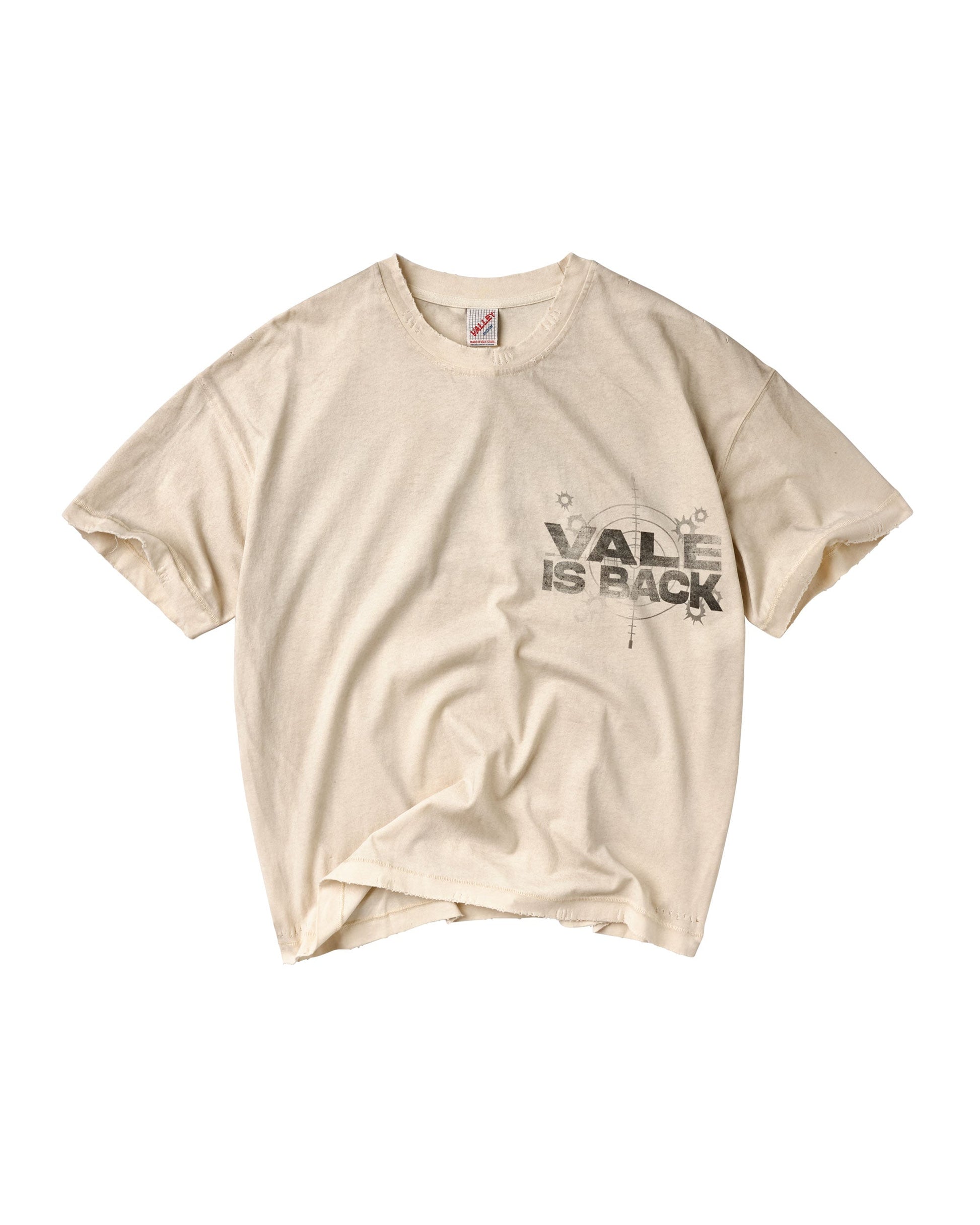 A cream-colored short-sleeve t-shirt with a distressed black graphic on the left chest that reads 'VALE IS BACK' with a compass design.